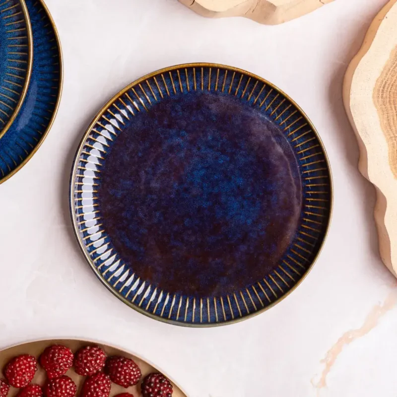 Okładka ceramiczna w głębokim odcieniu niebieskiego z złotymi detalami, elegancka zastawa do serwowania potraw, kolekcja Domowy Zakątek, stylowe naczynie na okazje specjalne i codzienne posiłki.