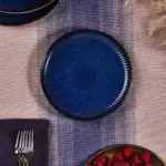 Smooth dark blue ceramic plate z dużym wykończeniem z metalu na brzegu, idealny na domowe obiady i kolacje, elegancki dodatek do zastawy stołowej, stylowe naczynie do serwowania jedzenia.