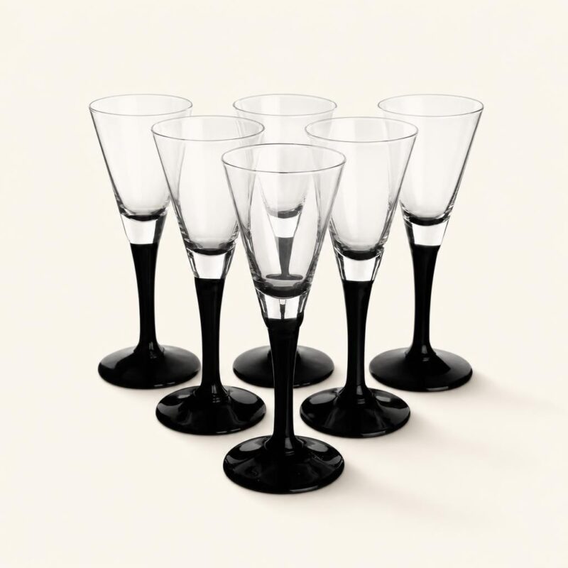 Szklanki do szampana z czarną podstawą i transparentnym kieliszkiem, elegancki zestaw na specjalne okazje, idealny do serwowania napojów alkoholowych.