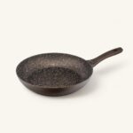 Patelnia ceramiczna z czarnym wnętrzem i ergonomiczną rączką, idealna do smażenia i gotowania na kuchni.
