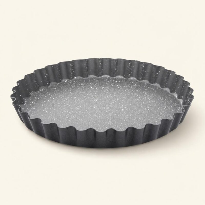 Czarna forma do tarty z falistymi krawędziami, idealna do pieczenia i serwowania wypieków, wykonana z wysokiej jakości materiałów ceramicznych i metalowych.