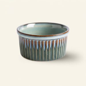 Ceramiczna miska w odcieniach zieleni i brązu z pionowymi żłobieniami, idealna do serwowania potraw, element dekoracyjny kuchni lub jadalni.